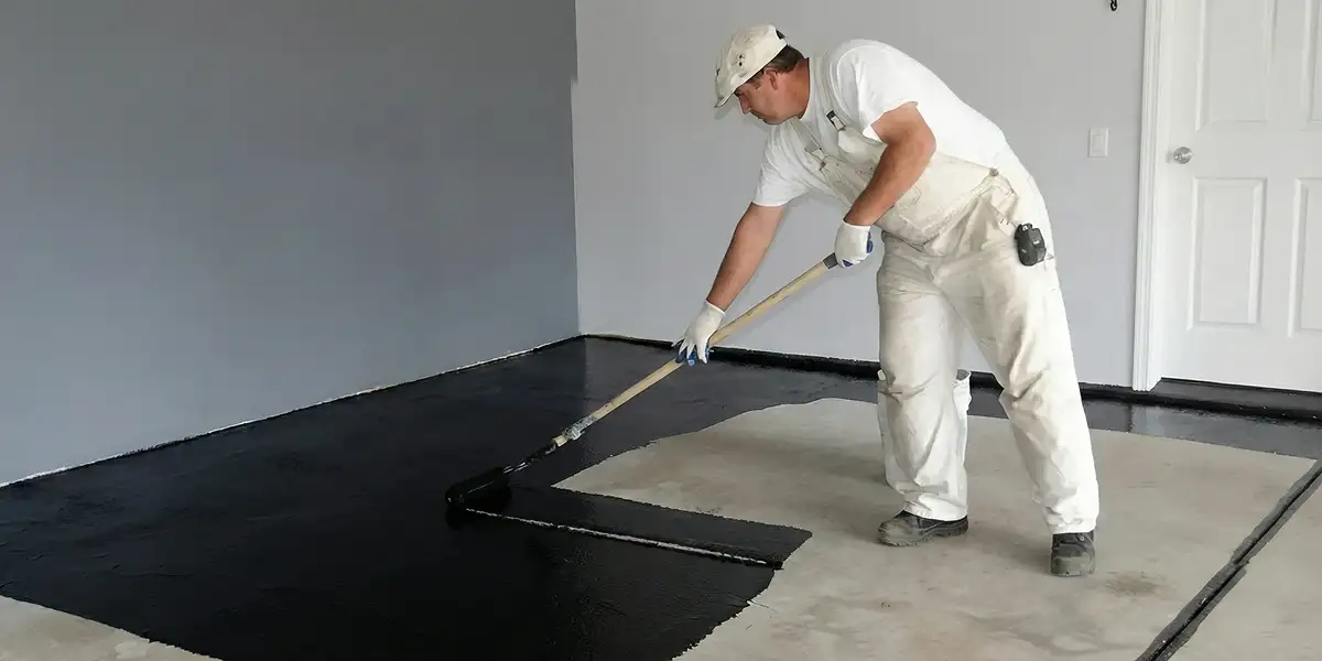 basement waterproofing professional applying waterproof coating to protect a basement floor in Houston, TX